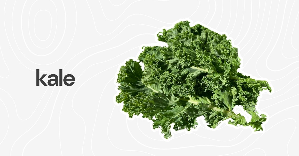 Fresh, curly kale leaves spread out on a plain background.