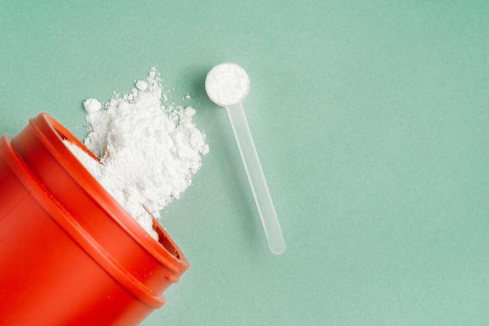 a red jar and a spoon with supplements