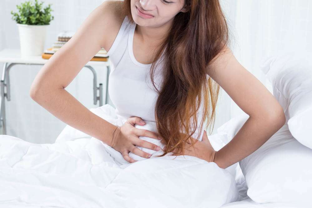 a woman holding to her belly suffering from poor gut health