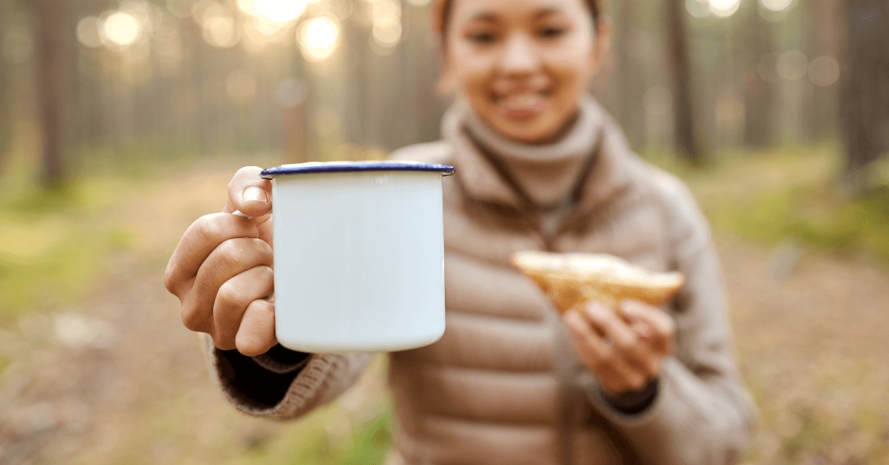 Close up of young asian woman with mug drinking mushroom coffee