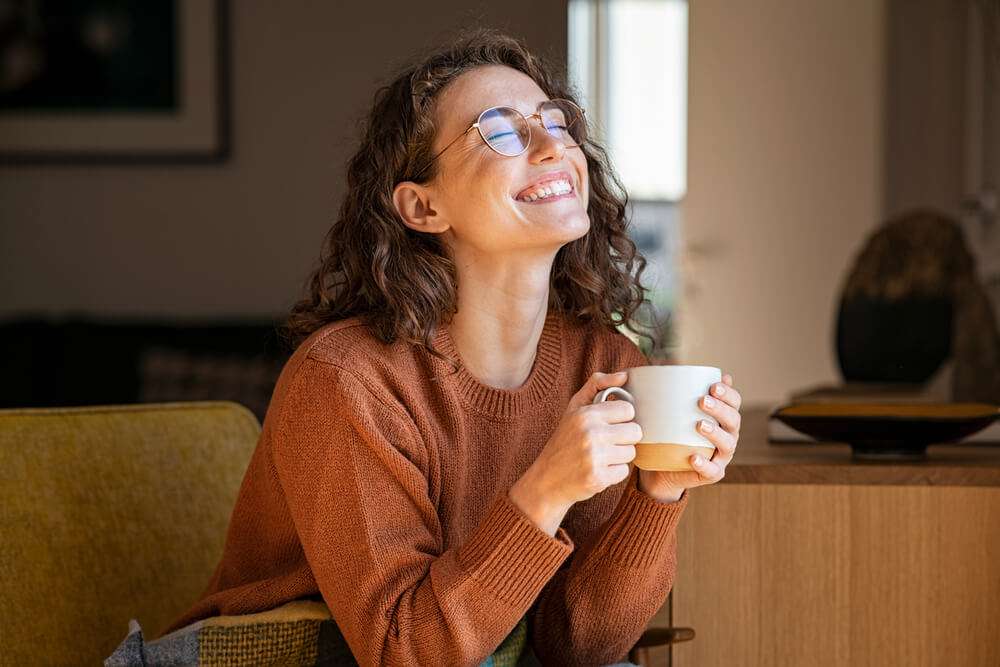 Portrait of joyful young woman enjoying a cup of water