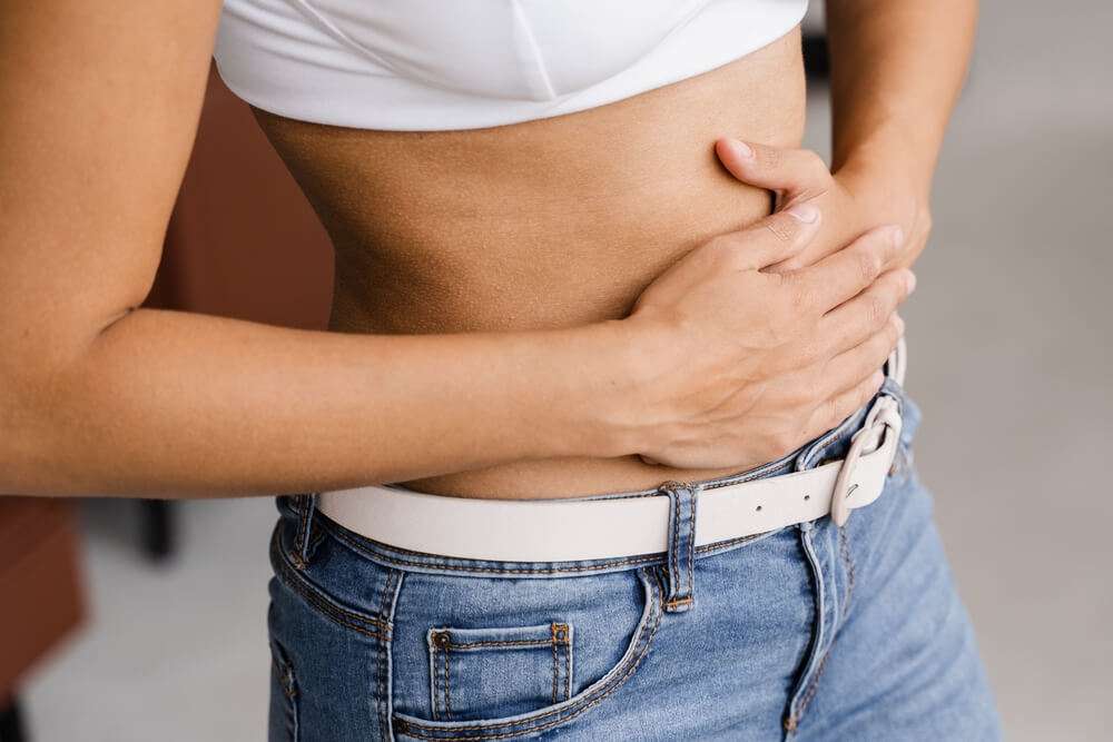 woman holding belly from stomach pain