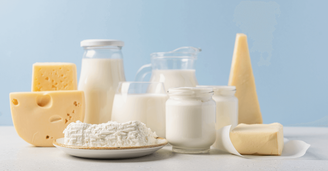 Cheese, curd cheese, milk, cream in glass jars and cut on a white table