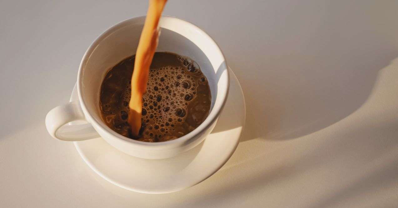 Coffee being poured in a white cup. Minimalistic.