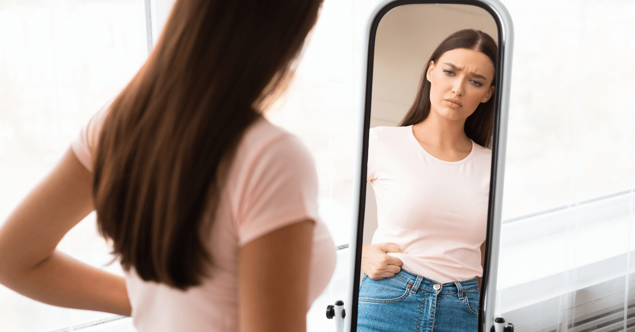 Woman Looking in the Mirror After Gaining some Weight