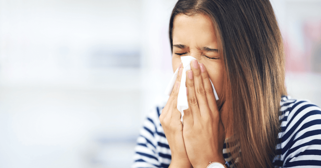 Woman Sneezing into a Tissue