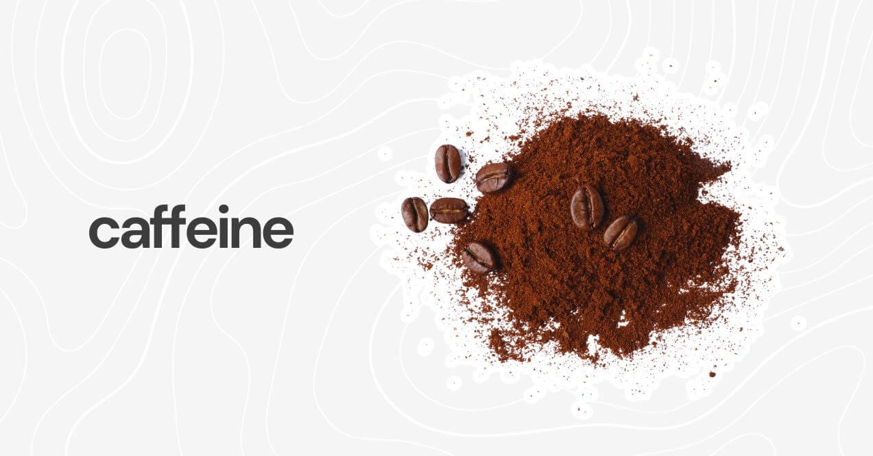 Pile of ground coffee with coffee beans scattered on a light background labeled 'caffeine.