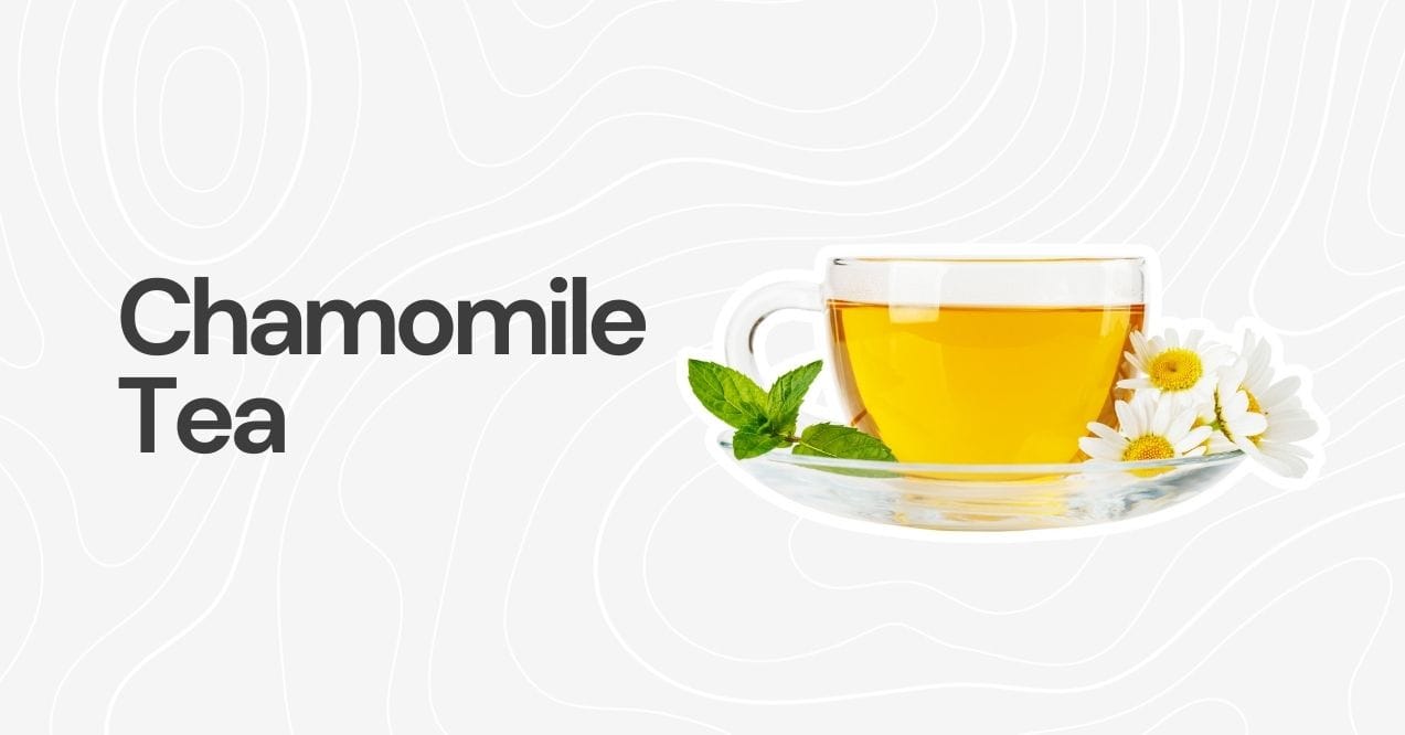 A clear cup of chamomile tea garnished with chamomile flowers and mint leaves.