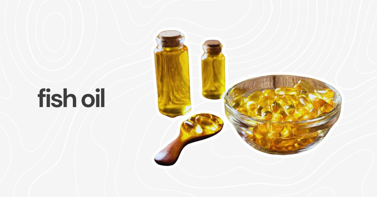 Fish oil capsules in a glass bowl alongside small bottles of golden liquid.