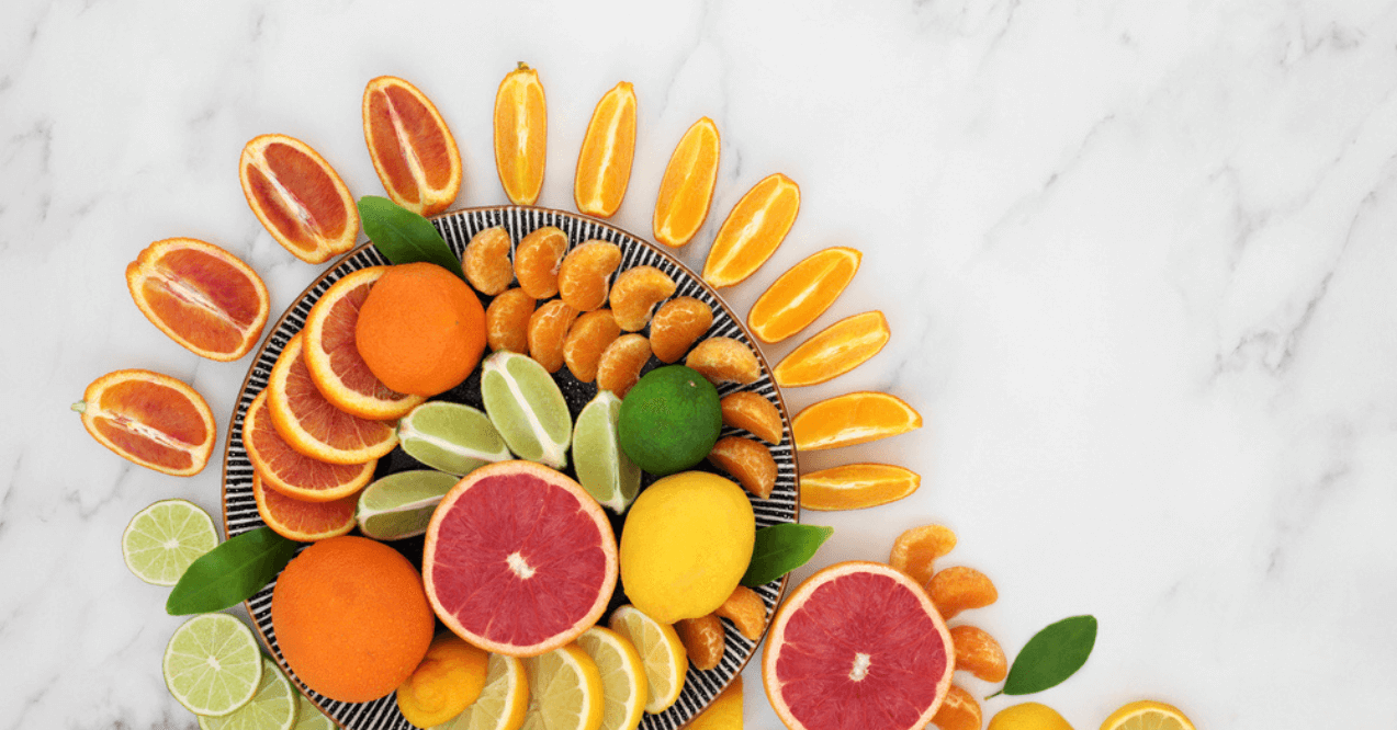 Citrus fruit high in antioxidants & vitamin c, with oranges, lemons, limes , mandarins & grapefruit on plates. Also high in anthocyanins, lycopene and dietary fibre.