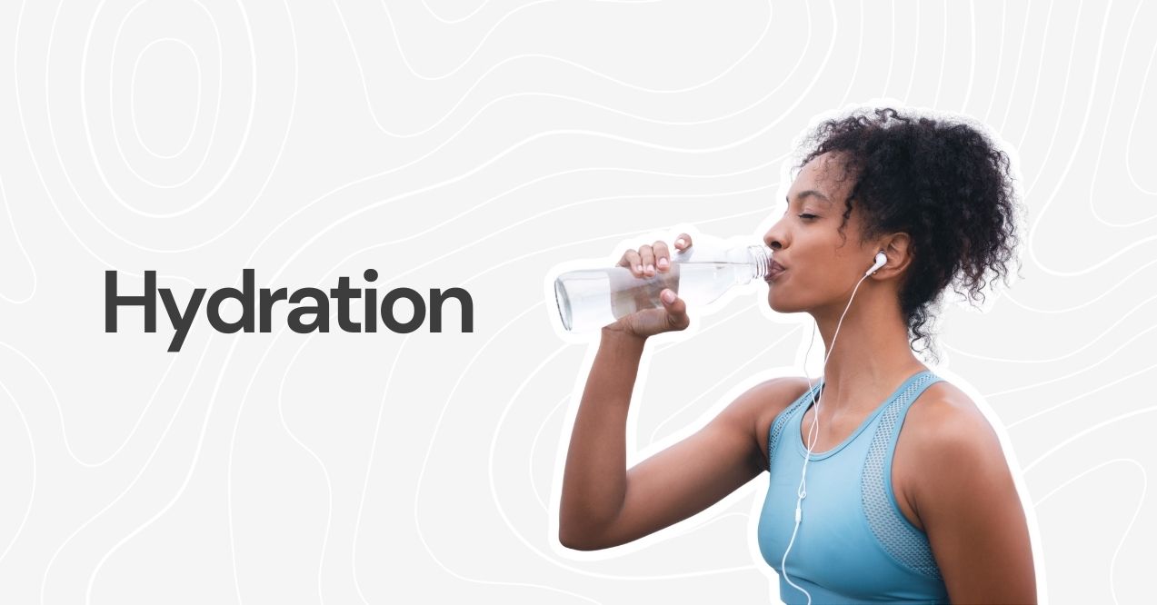 A woman drinking water from a bottle while wearing earphones.