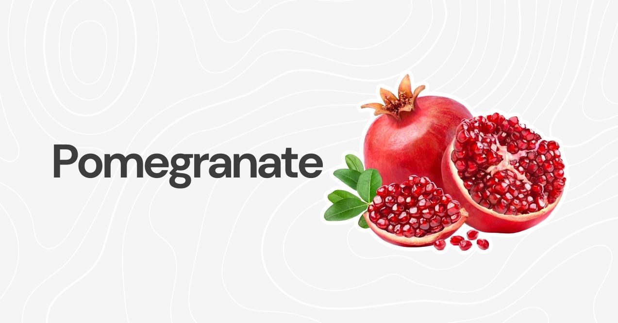 Whole pomegranate with seeds and leaves on a white background.