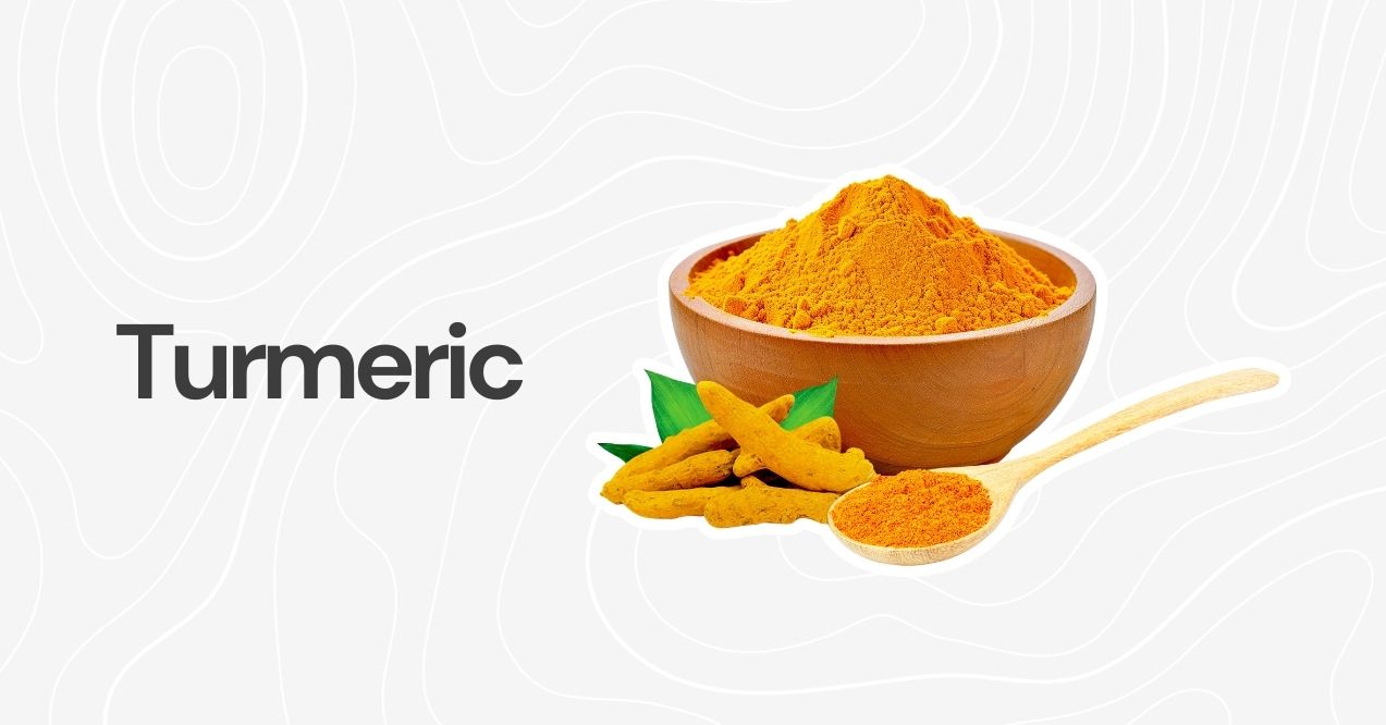 Turmeric powder and whole turmeric root in a wooden bowl with a spoon.