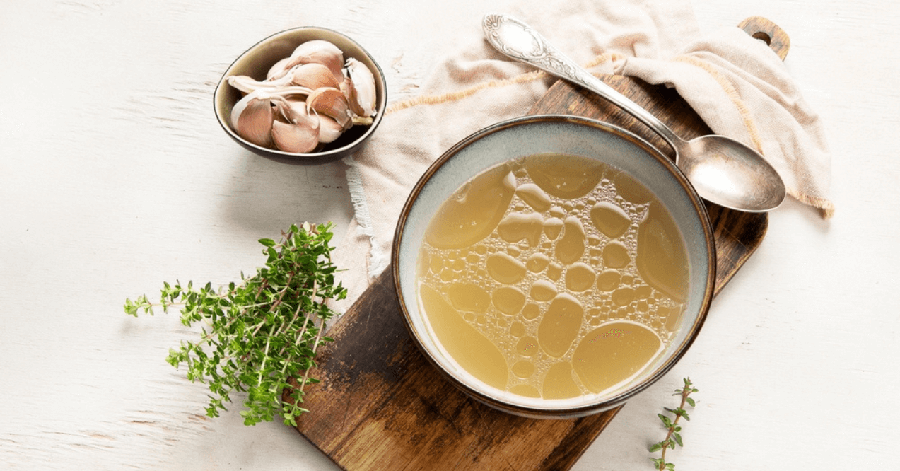 Broth in Bowl on gray background, healthy food, top view