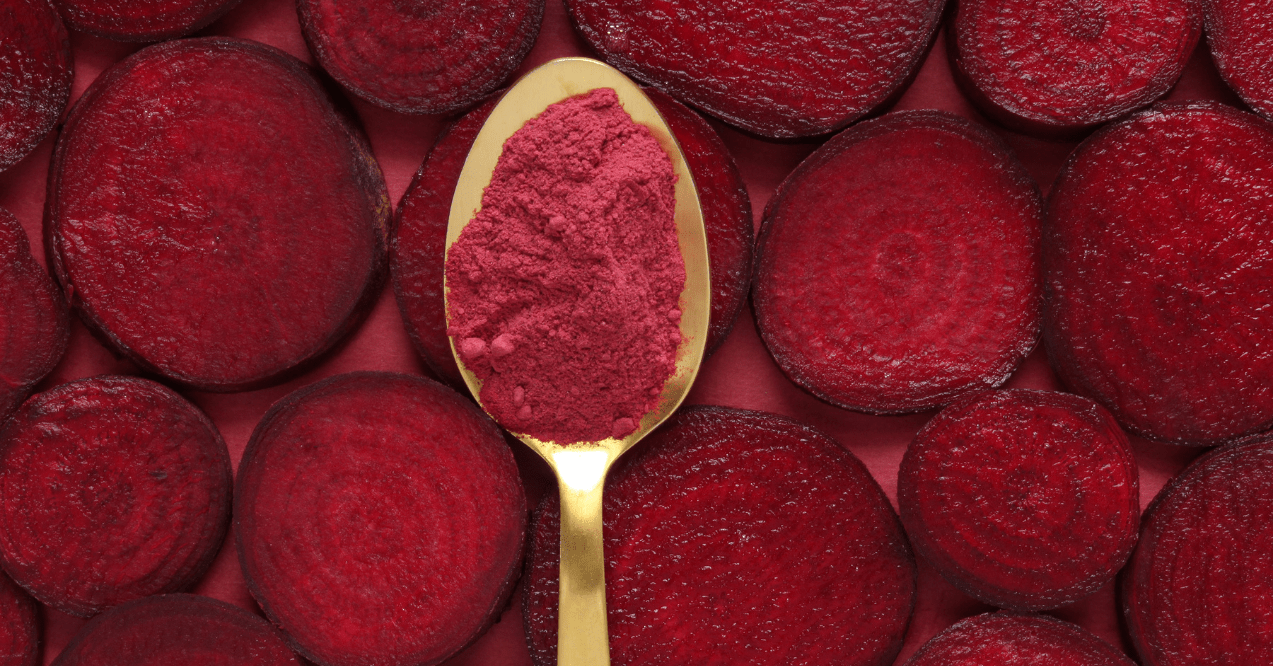 golden spoon with red powder and beetroot behind