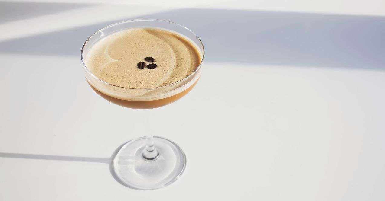 a glass of espresso martini in white classic clean background