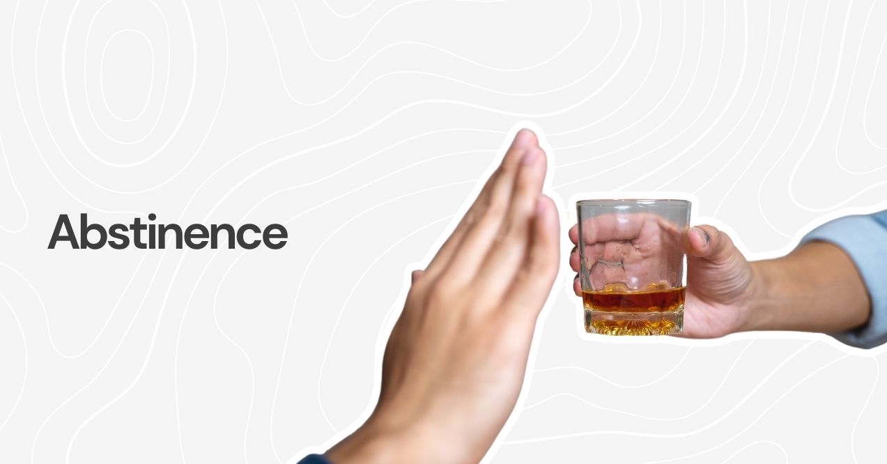 Hand rejecting a glass of alcohol to represent abstinence.