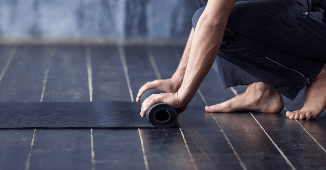 A person Rolling a Yoga Mat 