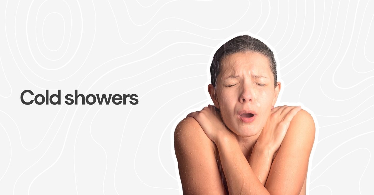 Person shivering under a cold shower, arms crossed for warmth.