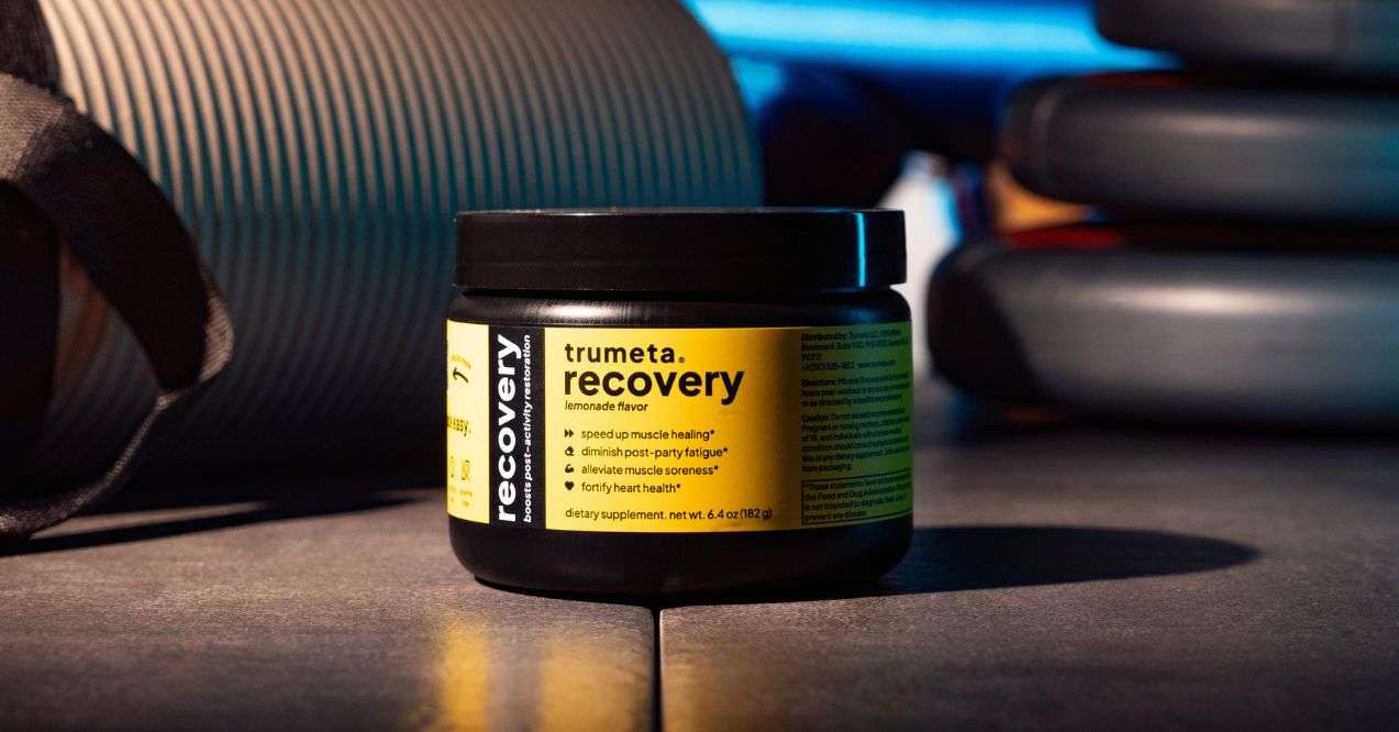 trumeta recovery powder packaging in the gym background zoomed in