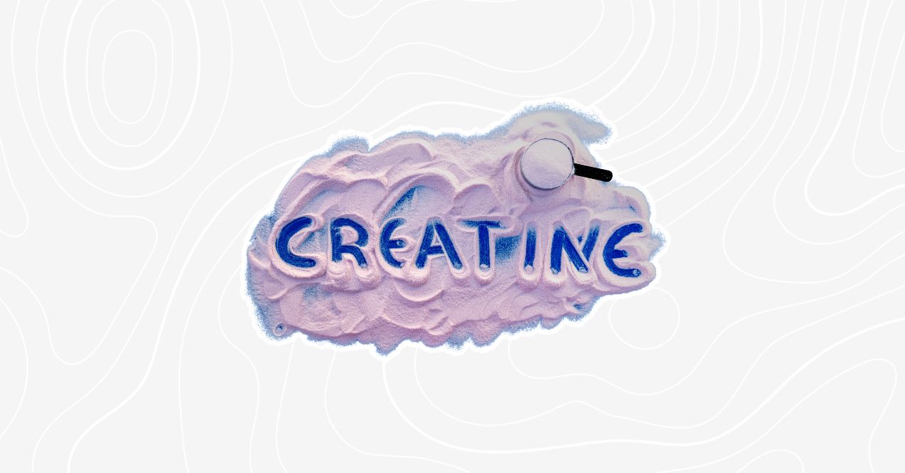 Scoop of creatine powder with the word 'Creatine' written in blue on top of the powder.