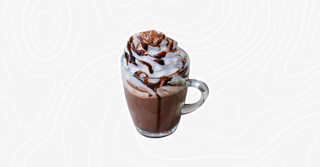 A glass of frosted mushroom coffee topped with whipped cream and chocolate drizzle.