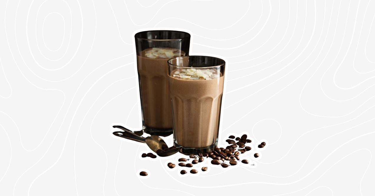 Two glasses of mushroom coffee smoothie with coffee beans scattered around, topped with sliced almonds.