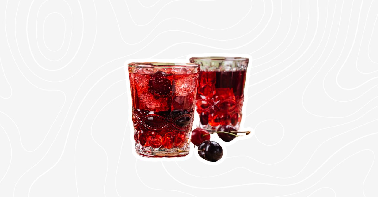 Two glasses of sleepy girl mocktail garnished with cherries and ice.