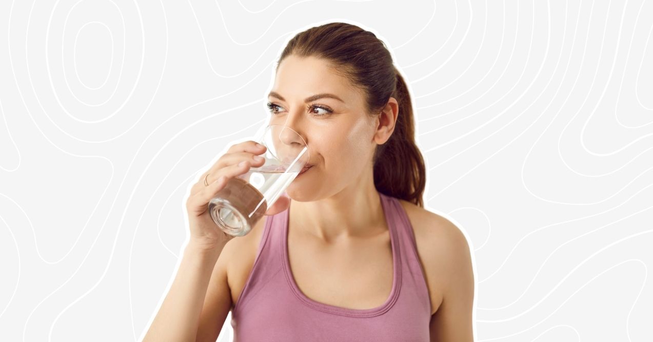 How Much Water to Drink With Creatine: Woman in pink tank top drinking water for hydration.