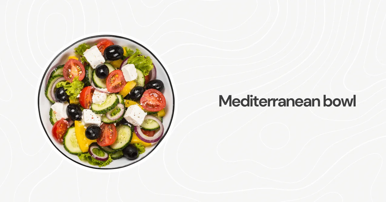 A vibrant Mediterranean salad bowl with feta cheese, olives, cucumbers, and tomatoes, drizzled with olive oil dressing.