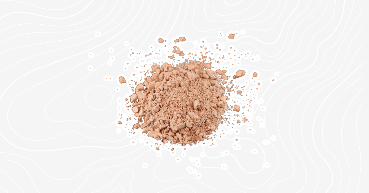 A pile of chocolate protein powder scattered on a white background with a subtle textured design.