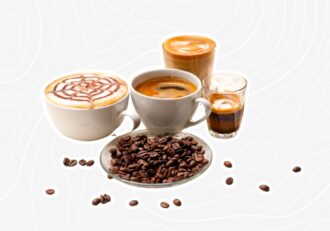 A variety of coffee drinks including cappuccino, espresso, and a plate of coffee beans displayed together.